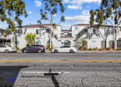 Thumbnail 10 of 21 - A street view with cars and apartment buildings.