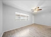Thumbnail 12 of 14 - A room with a ceiling fan and a window with blinds.
