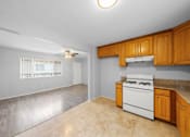 Thumbnail 3 of 14 - A kitchen with a white oven and wooden cabinets.