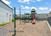 Thumbnail 25 of 32 - A playground with a slide and a green pole.
