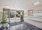 Thumbnail 12 of 18 - A view of a parking garage with a glass door and a wall of mailboxes.