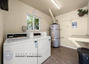 Thumbnail 19 of 32 - A room with a washing machine, dryer, and a water heater.