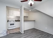 Thumbnail 9 of 17 - a kitchen with white cabinets and a stove and a ceiling fan