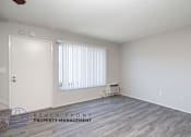 Thumbnail 17 of 17 - a living room with wood flooring and white walls and a window