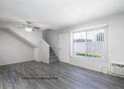 Thumbnail 8 of 17 - a living room with a large window and a ceiling fan