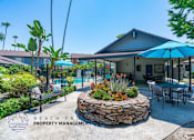 Thumbnail 1 of 17 - a patio with tables and umbrellas and a house