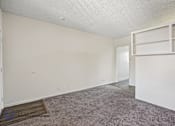 Thumbnail 2 of 18 - A room with a carpeted floor and white walls.