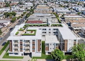 Thumbnail 10 of 33 - A large white building with a green roof is surrounded by smaller buildings.