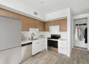 Thumbnail 1 of 33 - A modern kitchen with a refrigerator, sink, stove, and cabinets.