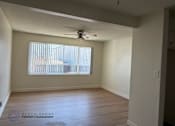 Thumbnail 4 of 6 - A room with a ceiling fan and a window with blinds.