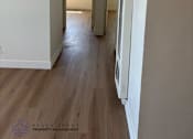Thumbnail 5 of 6 - A long hallway with a logo for Beach Front Property Management in the bottom left corner.