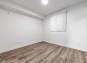 Thumbnail 28 of 33 - A room with wooden flooring and a window with blinds.