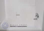 Thumbnail 9 of 10 - a white bathroom with a shower and a sink