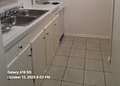 Thumbnail 5 of 10 - A kitchen with white cabinets and a white stove top oven.
