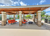 Thumbnail 32 of 40 - A covered patio area with a pool table and seating.