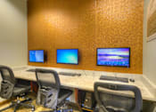 Thumbnail 21 of 40 - A conference room with a table, chairs, and three monitors.