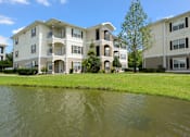 Thumbnail 39 of 40 - A large apartment complex with a pond in front.