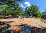 Thumbnail 36 of 40 - A playground with a green bench and a slide.