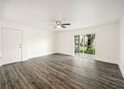 Thumbnail 32 of 42 - an empty living room with a ceiling fan and a window