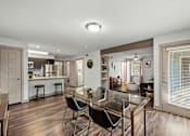 Thumbnail 1 of 36 - A modern kitchen with a glass table and bar stools.