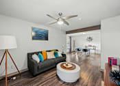 Thumbnail 4 of 36 - A living room with a grey couch and a wooden floor.