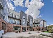 Thumbnail 1 of 22 - a picture of an apartment complex with a blue sky in the background