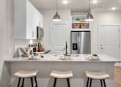 Thumbnail 4 of 47 - A kitchen with a white countertop and stools.