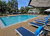 Thumbnail 20 of 25 - A pool with blue chairs and a white umbrella.