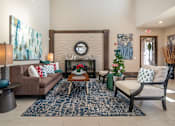Thumbnail 16 of 29 - A living room with a brown couch, a coffee table, and a fireplace.