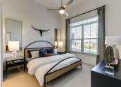Thumbnail 14 of 23 - a bedroom with a large bed and a ceiling fan
