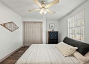 Thumbnail 13 of 36 - A bedroom with a bed, dresser, and ceiling fan.