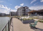 Thumbnail 19 of 22 - a boardwalk overlooking a lake with a building in the background