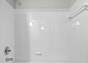Thumbnail 17 of 36 - A white bathroom with a white tub and white tiles.