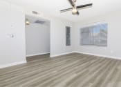 Thumbnail 4 of 20 - an empty living room with a ceiling fan and a window