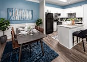 Thumbnail 2 of 25 - A modern kitchen with a dining table set for two.
