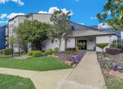Thumbnail 25 of 26 - a white building with a gray roof and a sidewalk leading to the front door