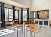 Thumbnail 15 of 29 - A modern dining area with a bar and chairs.