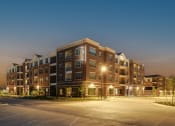 Thumbnail 8 of 23 - a large apartment building at night with street lights