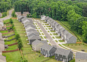 Thumbnail 12 of 32 - A suburban neighborhood with houses and a road.