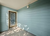 Thumbnail 18 of 36 - A small door with a window is on the left side of a blue wall.