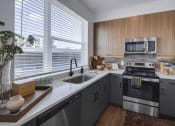 Thumbnail 2 of 22 - a kitchen with gray cabinets and white countertops