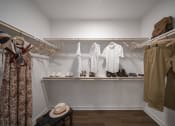Thumbnail 7 of 22 - a walk in closet with white walls and wooden shelves