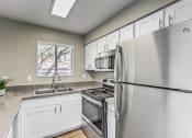 Thumbnail 2 of 20 - a kitchen with stainless steel appliances and white cabinets