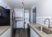 Thumbnail 4 of 22 - a kitchen with white cabinets and stainless steel appliances and a sink