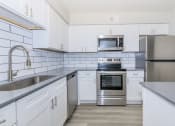 Thumbnail 1 of 20 - a white kitchen with stainless steel appliances and white cabinets