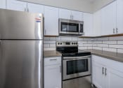 Thumbnail 1 of 22 - an empty kitchen with stainless steel appliances and white cabinets