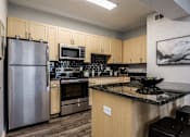 Thumbnail 3 of 28 - a kitchen with stainless steel appliances and granite counter tops