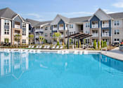Thumbnail 33 of 47 - A large swimming pool in front of apartment buildings.