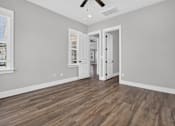 Thumbnail 23 of 33 - A room with a wooden floor and a ceiling fan.