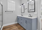 Thumbnail 24 of 33 - A bathroom with a double sink vanity and a mirror above it.